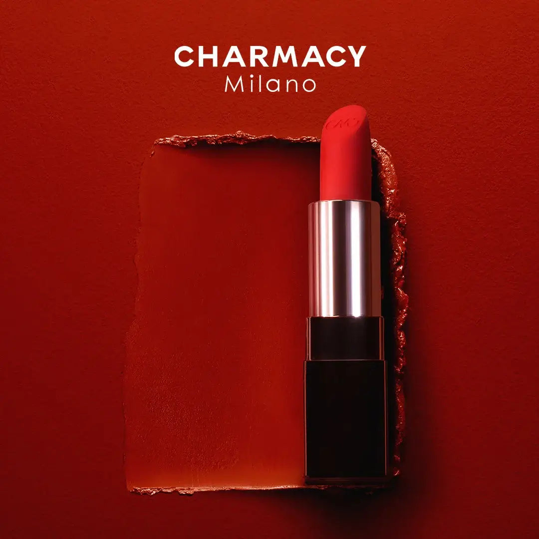 Matte velvet lipstick CHARMACY in bold red color displayed on a vibrant red background.