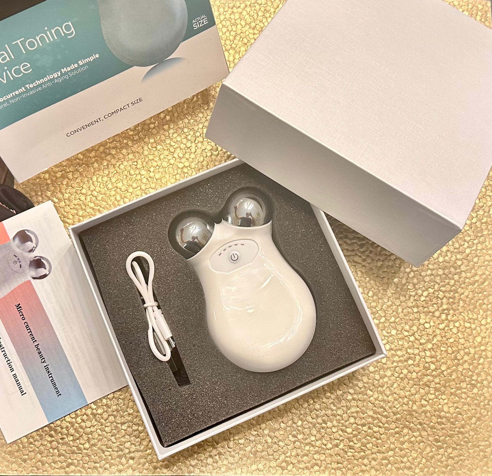 Compact facial massager for microcurrent skin firming treatment